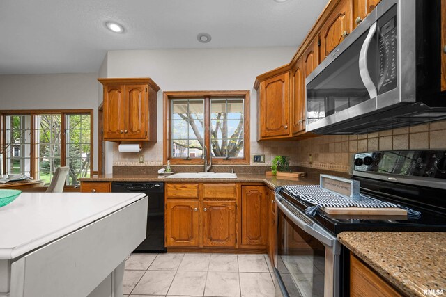 kitchen with decorative backsplash, recessed lighting, brown cabinets, a sink, and stainless steel appliances