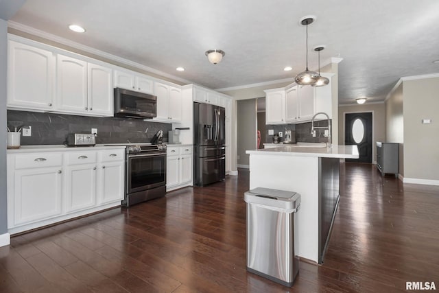 409 Arbor Dr, Carterville, IL 62918 - kitchen with dark wood finished floors, stainless steel appliances, a sink, crown molding, and a peninsula