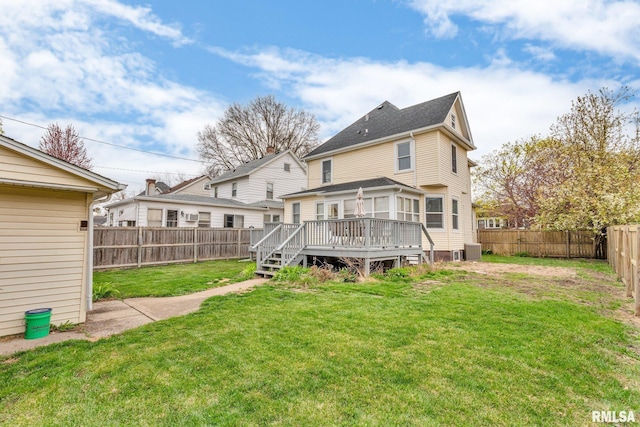 back of house featuring a wooden deck, a fenced backyard, and a yard