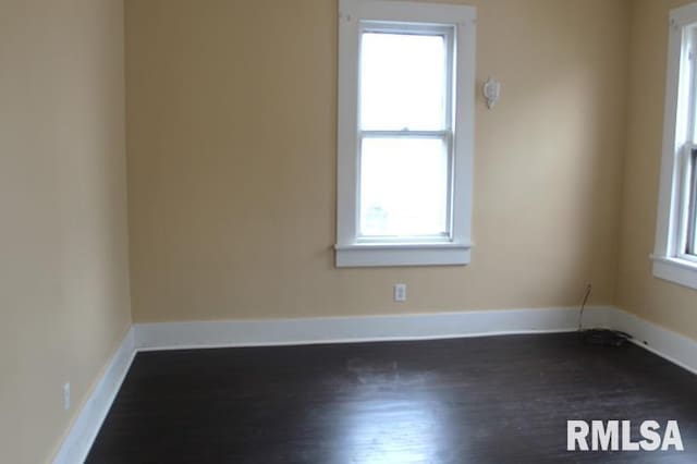 unfurnished room with dark wood finished floors and baseboards