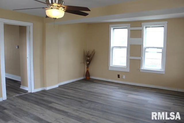 spare room featuring ceiling fan, baseboards, a healthy amount of sunlight, and wood finished floors