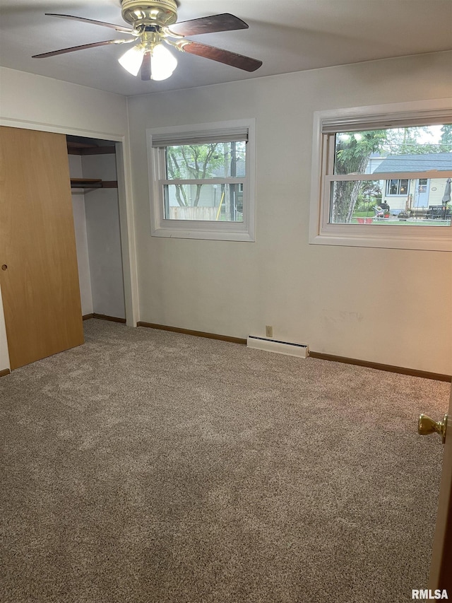 1725 Elmwood Ln, Bettendorf, IA 52722 - unfurnished bedroom with multiple windows, a closet, carpet, and a baseboard heating unit