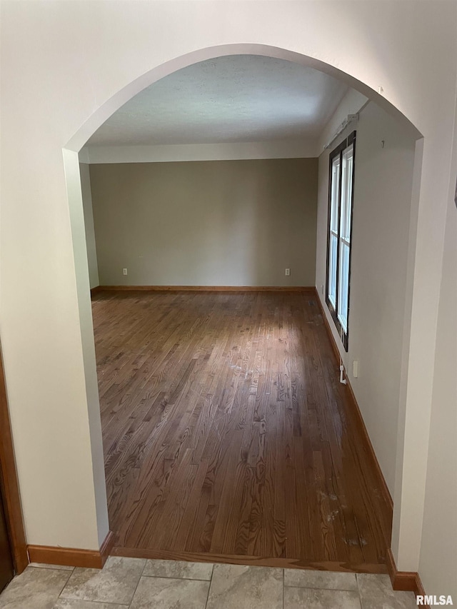 5833 Taylor St, Davenport, IA 52806 - empty room featuring wood finished floors, baseboards, and arched walkways