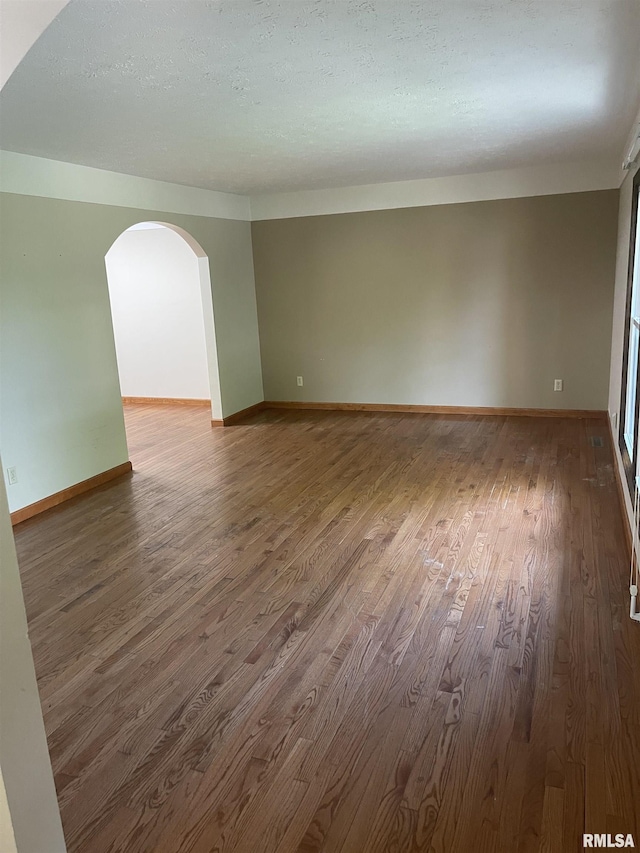 5833 Taylor St, Davenport, IA 52806 - empty room with wood finished floors, arched walkways, and baseboards