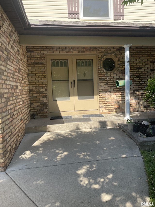 5833 Taylor St, Davenport, IA 52806 - view of exterior entry with brick siding, french doors, and a porch