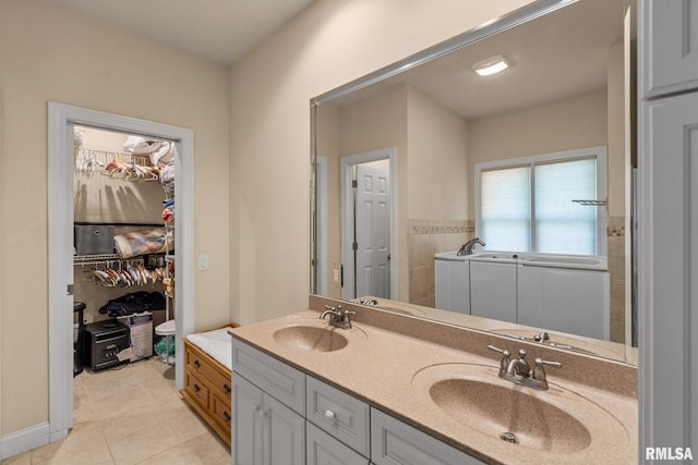 bathroom with a bath, double vanity, tile patterned flooring, and a sink