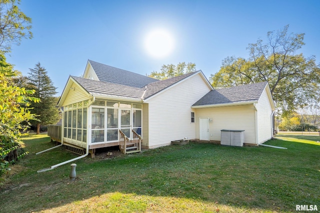back of house with a sunroom and a yard