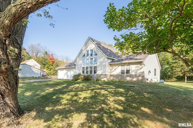 view of front of property with stone siding, a front yard, and a garage