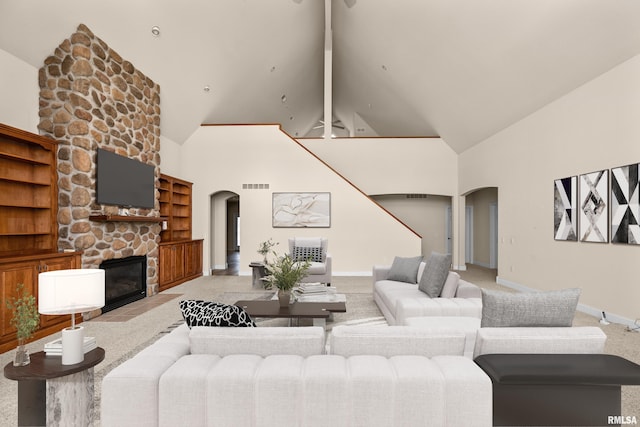 living area with high vaulted ceiling, arched walkways, and visible vents