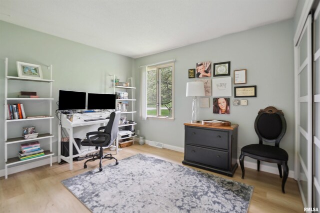 office space featuring baseboards, wood finished floors, and visible vents