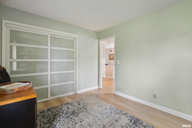 unfurnished office featuring baseboards, visible vents, and wood finished floors