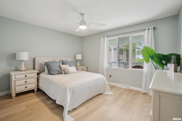 bedroom featuring light wood-style floors, baseboards, ceiling fan, and visible vents