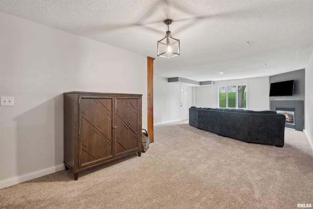 living room with light colored carpet, baseboards, a textured ceiling, and a tiled fireplace