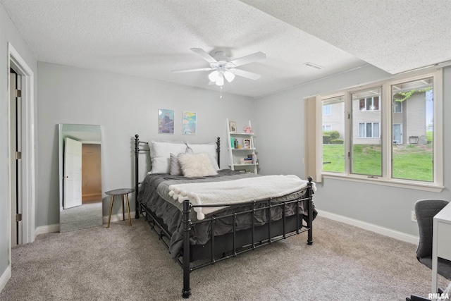 carpeted bedroom featuring baseboards, a ceiling fan, a textured ceiling, and visible vents