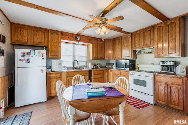 kitchen featuring brown cabinets, light wood-type flooring, a sink, and white appliances