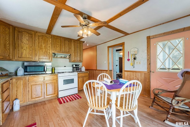 kitchen featuring light wood-style floors, ceiling fan, a wainscoted wall, stainless steel microwave, and gas range gas stove