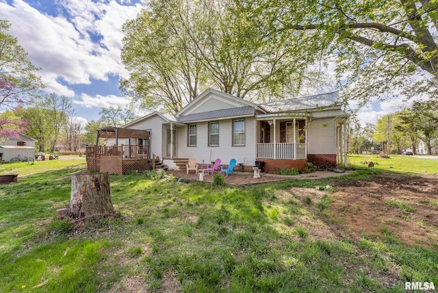 rear view of house with a patio area, a yard, and a deck