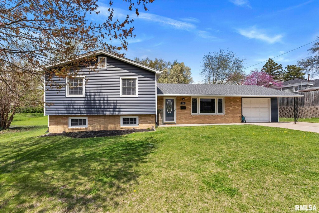 1524 Hickory Ln, Bettendorf, IA 52722 - split level home featuring a front yard, concrete driveway, and an attached garage