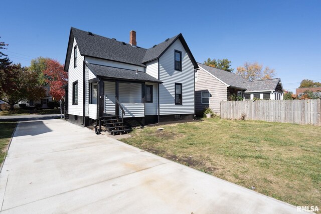 2129 Washington St, Davenport, IA 52804 - rear view of house featuring a chimney, fence, driveway, a lawn, and roof with shingles