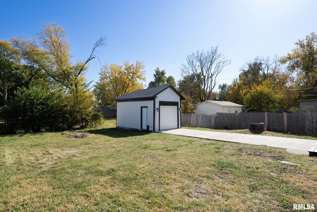 2129 Washington St, Davenport, IA 52804 - view of yard featuring an outdoor structure, a detached garage, concrete driveway, and fence