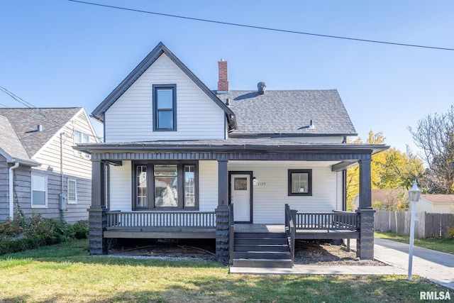 2129 Washington St, Davenport, IA 52804 - bungalow-style home featuring roof with shingles, a chimney, covered porch, fence, and a front yard