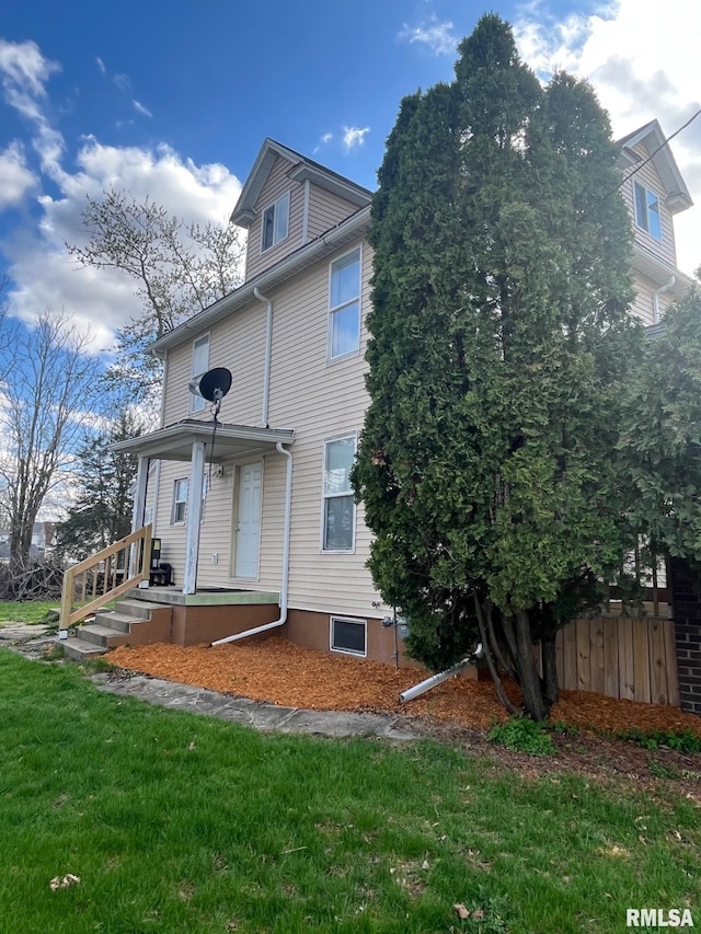 rear view of property featuring a yard and fence