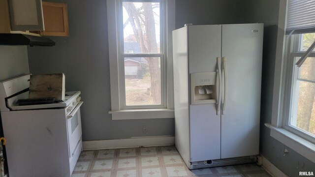 1306 Davie St, Davenport, IA 52804 - kitchen featuring white appliances, plenty of natural light, light flooring, and under cabinet range hood