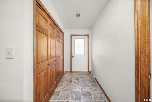 entryway with baseboards and stone finish floor