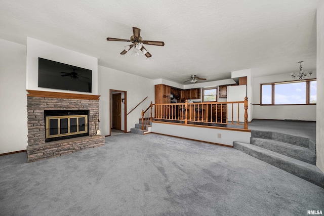 unfurnished living room featuring a textured ceiling, ceiling fan, stairway, a fireplace, and carpet floors