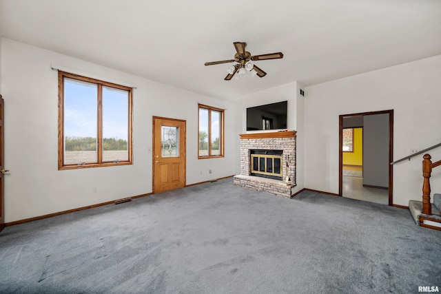 unfurnished living room featuring baseboards, a brick fireplace, ceiling fan, and carpet floors