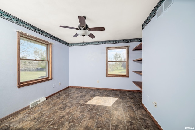 empty room featuring plenty of natural light, visible vents, baseboards, and a ceiling fan