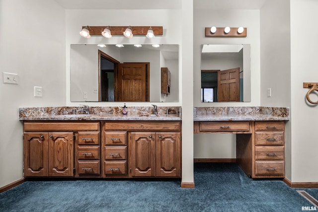 full bath featuring carpet flooring, double vanity, baseboards, and a sink