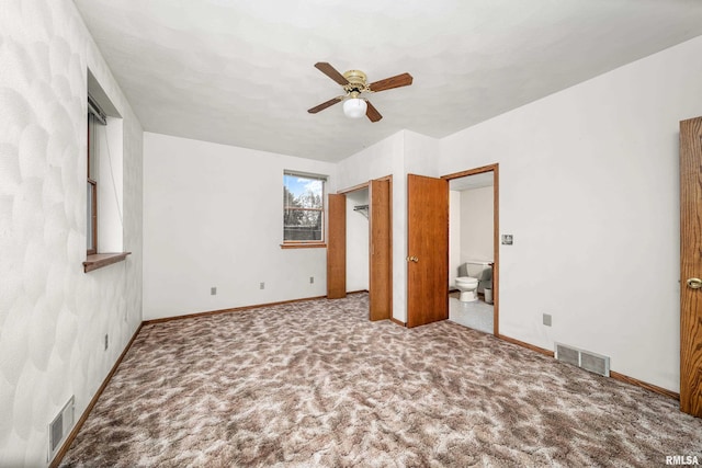unfurnished bedroom featuring carpet, ensuite bathroom, visible vents, and baseboards