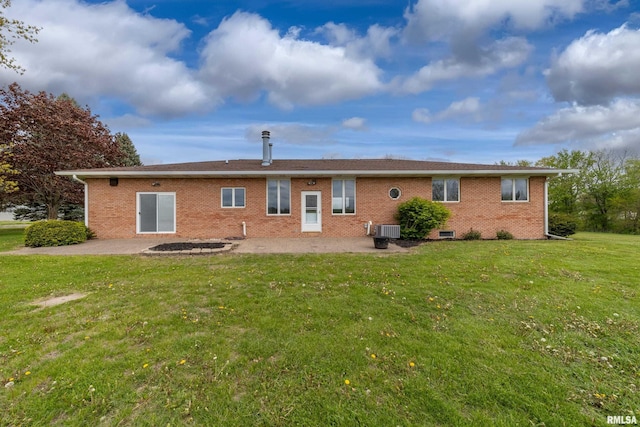 back of house with a patio area, brick siding, and a lawn