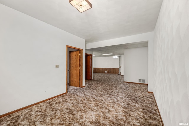carpeted empty room featuring baseboards and visible vents