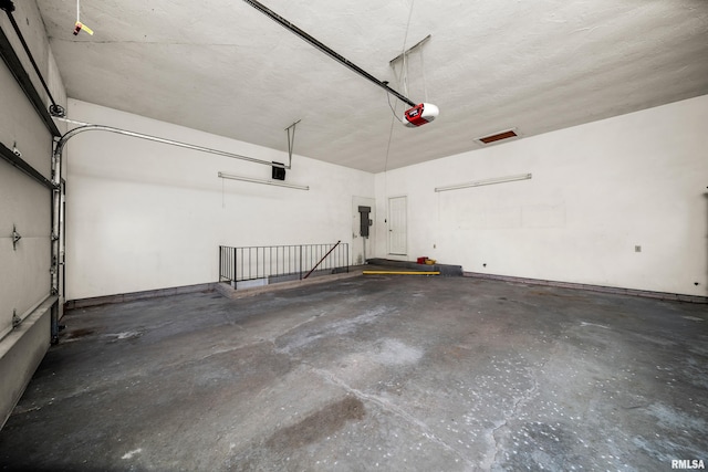 garage with electric panel and a garage door opener