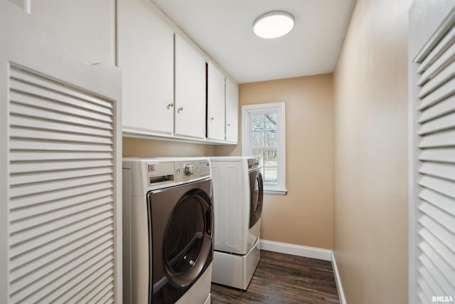 clothes washing area with washing machine and dryer, baseboards, cabinet space, and dark wood-style floors