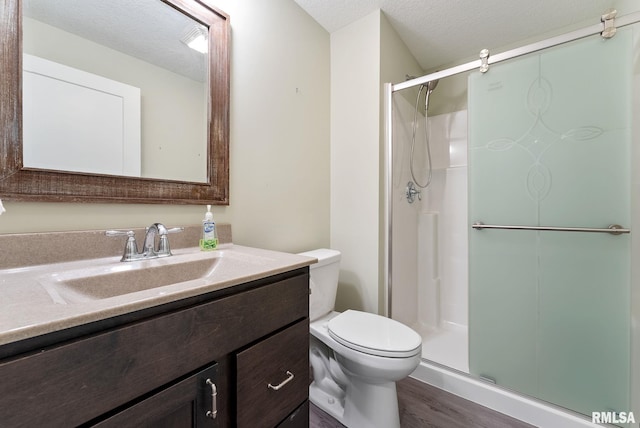 4743 Pheasant Creek Ave, Davenport, IA 52807 - bathroom with a shower stall, wood finished floors, toilet, vanity, and a textured ceiling