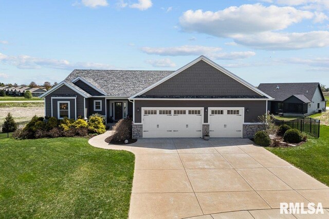 view of front of home featuring a front yard, a garage, stone siding, concrete driveway, and fence