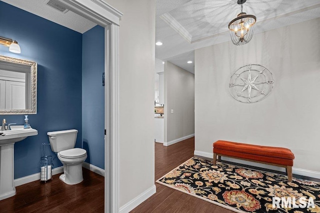 bathroom featuring wood finished floors, an inviting chandelier, toilet, baseboards, and visible vents