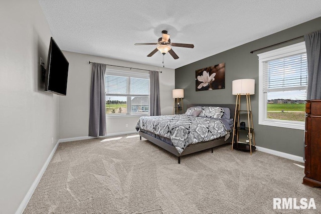 bedroom with a textured ceiling, carpet floors, and baseboards