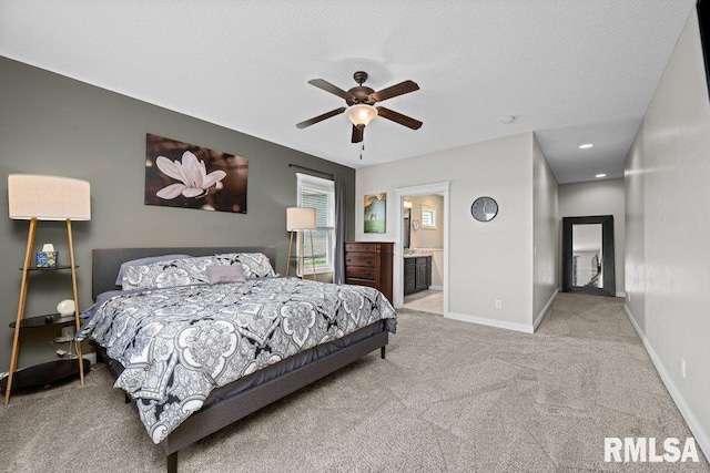 bedroom featuring a textured ceiling, baseboards, carpet, a ceiling fan, and ensuite bath