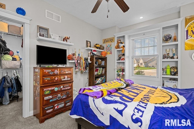 bedroom featuring a textured ceiling, carpet flooring, visible vents, ceiling fan, and a closet