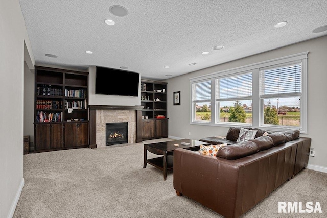 carpeted living area featuring baseboards, recessed lighting, a textured ceiling, and a fireplace