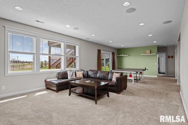 carpeted living room with baseboards, visible vents, a textured ceiling, and recessed lighting