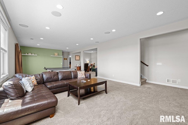 carpeted living area with recessed lighting, stairway, visible vents, baseboards, and a textured ceiling