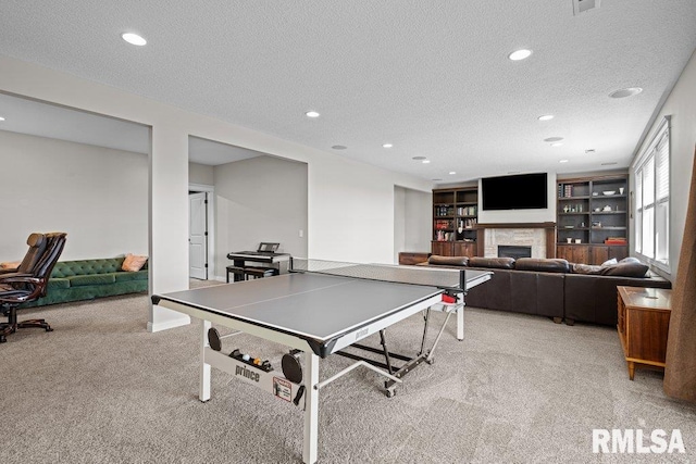 playroom featuring recessed lighting, light carpet, a textured ceiling, and a fireplace