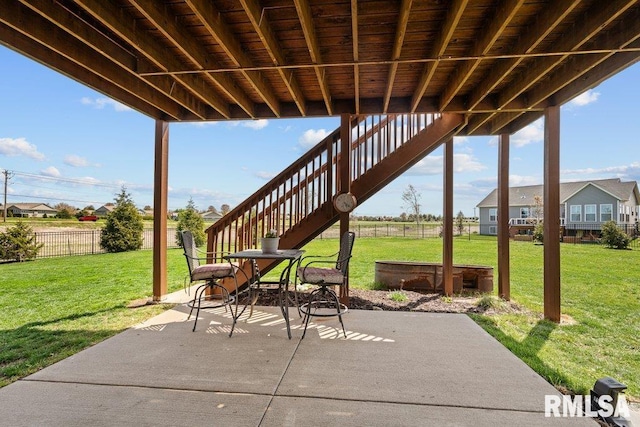 view of patio featuring fence and stairway