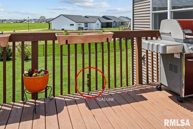 wooden deck featuring a lawn, fence, area for grilling, and a residential view