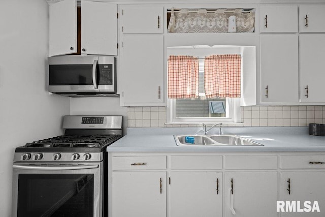1117 S Ohio Ave, Davenport, IA 52802 - kitchen featuring a sink, decorative backsplash, stainless steel appliances, light countertops, and white cabinetry